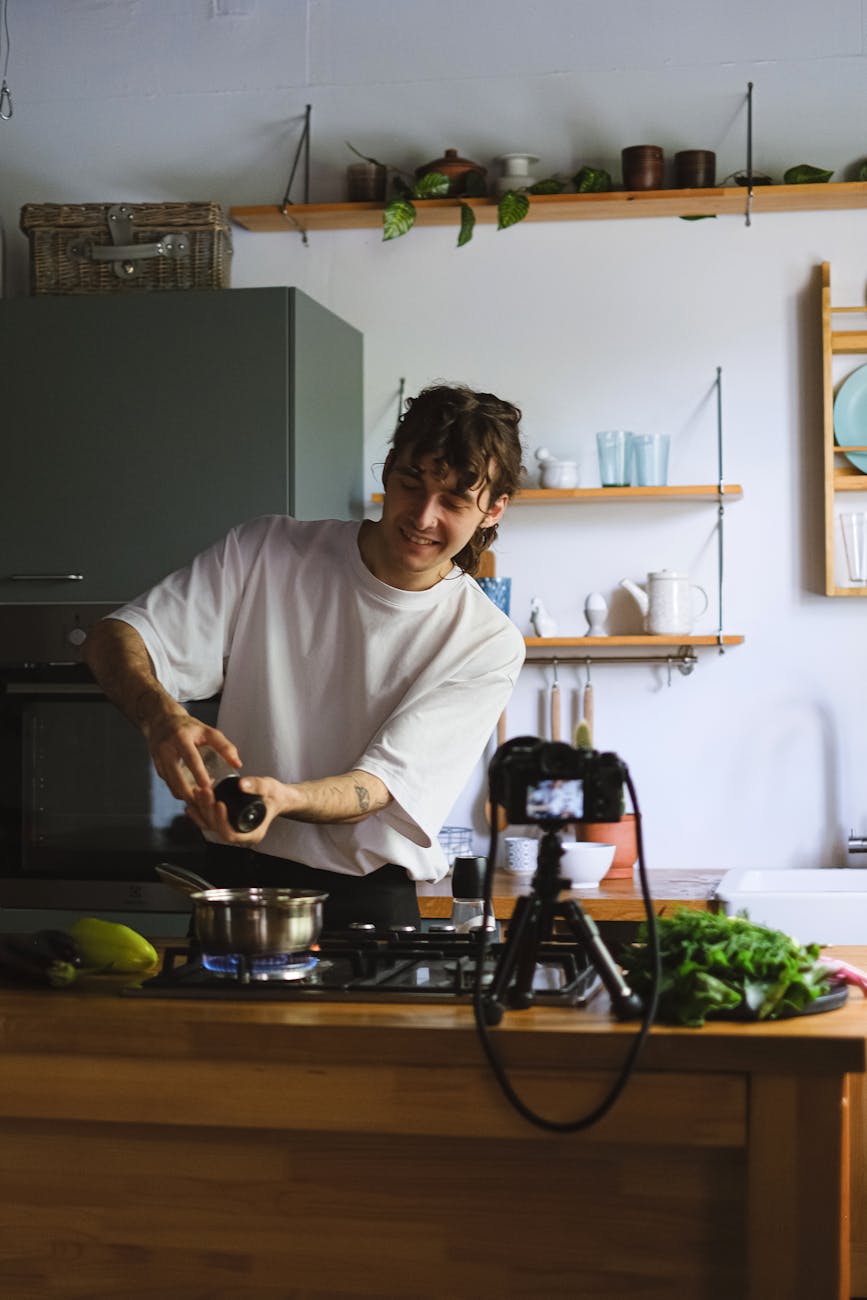 vlogger recording himself cooking in a kitchen
