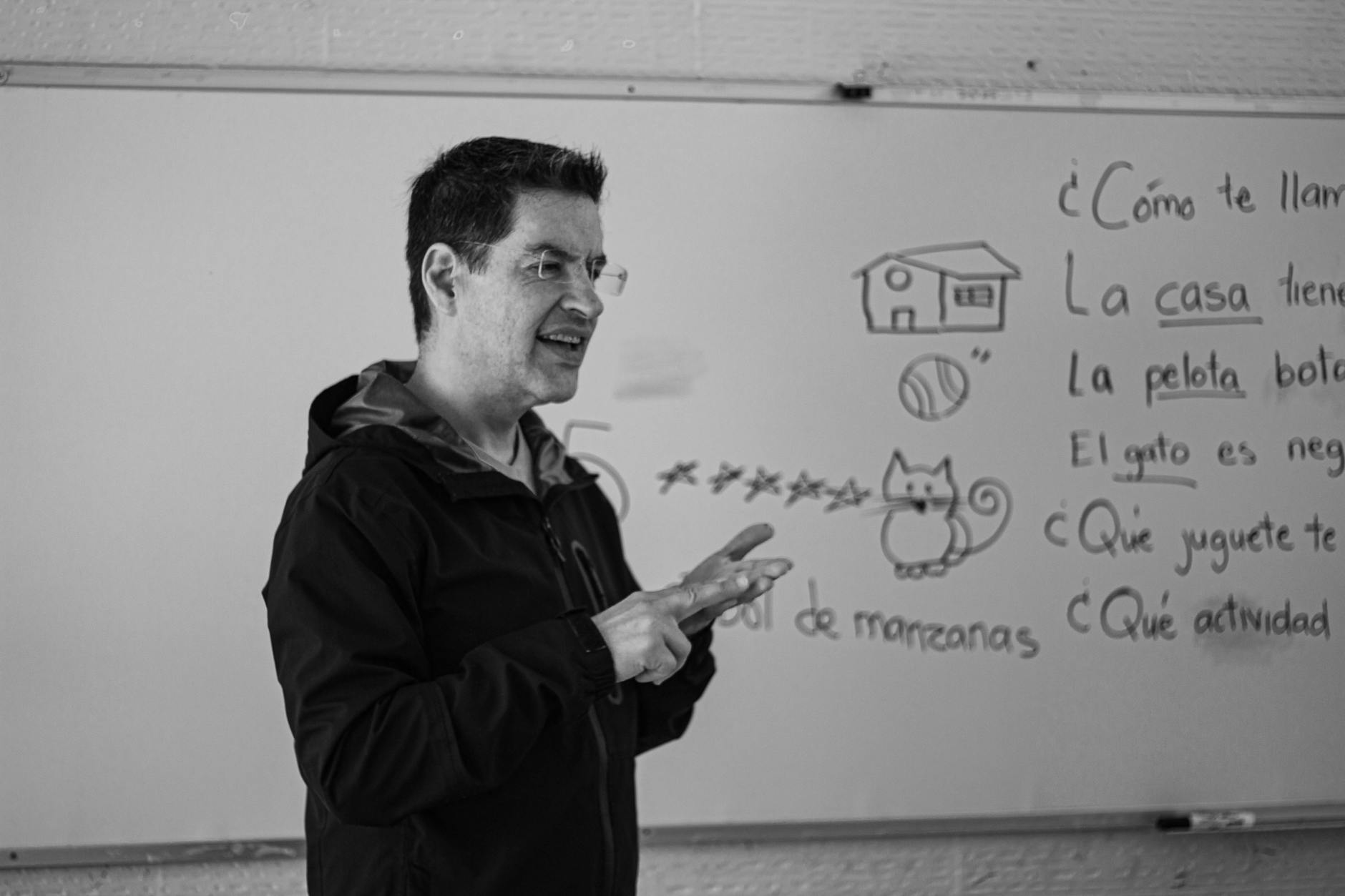 black and white photo of a teaching standing in a classroom and teaching spanish