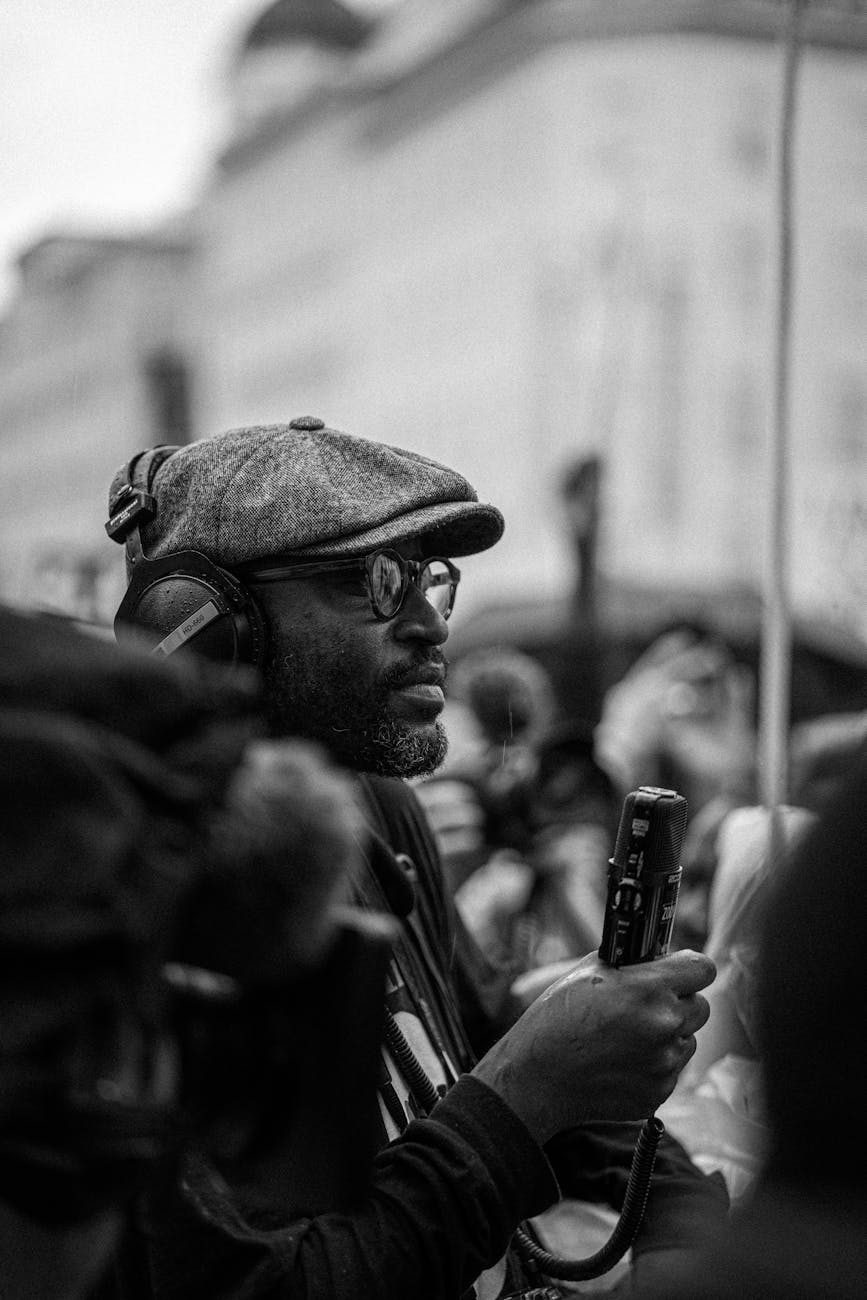 black journalist in headset with microphone during manifestation